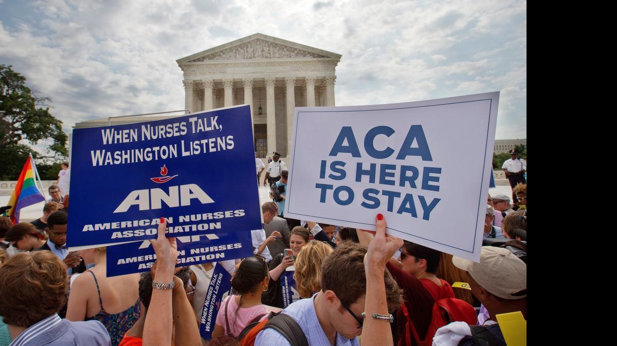 
Supporters of the Affordable Care Act hold up signs as the opinion for health care is reported outside of the Supreme Court in Washington, Thursday June 25, 2015. The Supreme Court on Thursday upheld the nationwide tax subsidies under President Obama’s health care overhaul.
