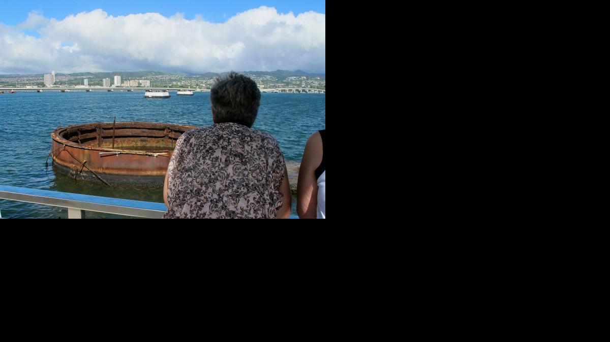 
Visitors look out at the sunken USS Arizona from a memorial atop the rusting battleship in Pearl Harbor, Hawaii. More than 900 sailors and Marines killed when Japan bombed Pearl Harbor are still entombed in the ship.
