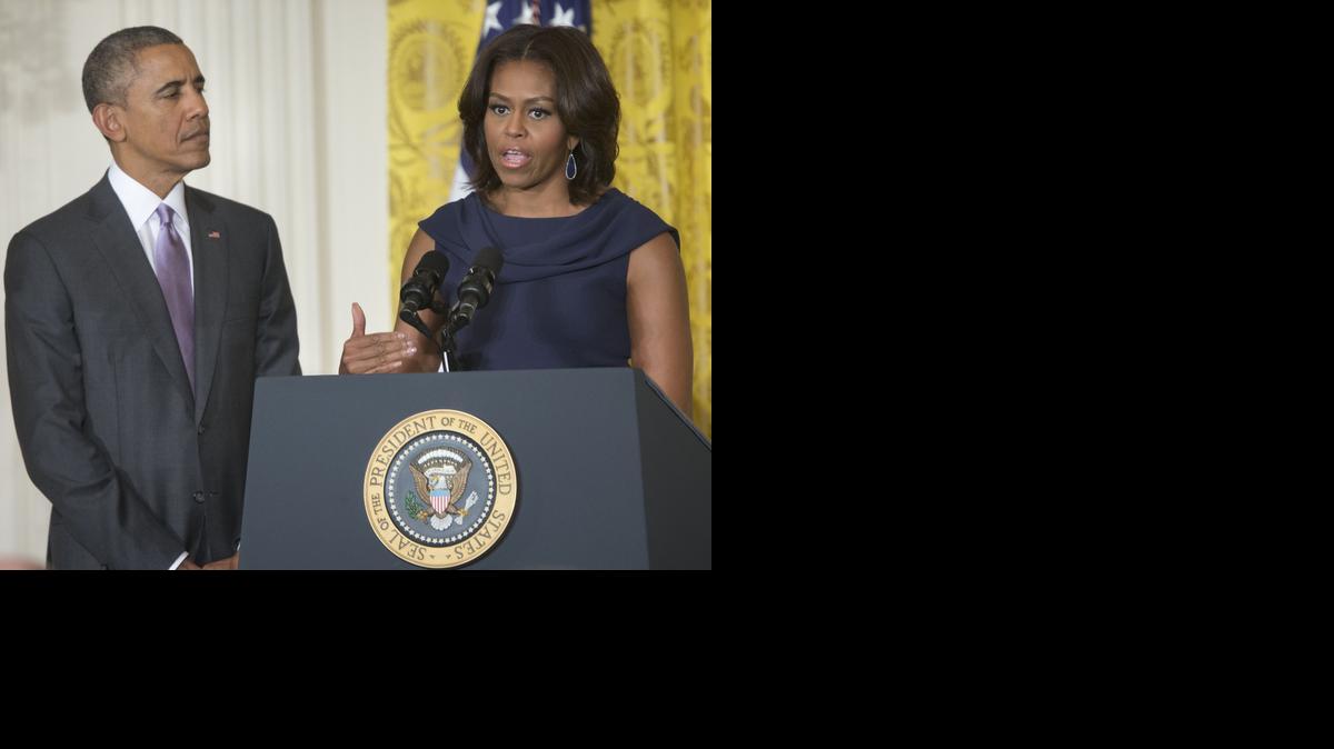 
President Obama listens as first lady Michelle Obama speaks at the White House in Washington, Tuesday. They announced their “Let Girls Learn” initiative to expand efforts to help young girls get an education.
