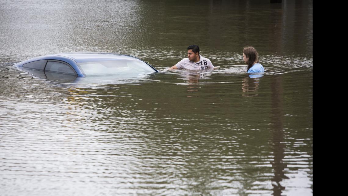 
Roberto Salas, left, and Lewis Sternhagen check a flooded car on the frontage road between South Loop West Freeway and South Post Oak Road near the Willow Waterhole Bayou, Tuesday, May 26, 2015, in Houston. Floodwaters kept rising Tuesday across much of Texas as storms dumped almost another foot of rain on the Houston area, stranding hundreds of motorists and inundating the highways. (Marie D. De Jesus/Houston Chronicle via AP) 
