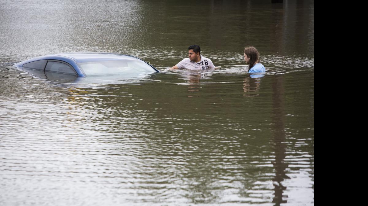 
Roberto Salas, left, and Lewis Sternhagen check a flooded car on the frontage road between South Loop West Freeway and South Post Oak Road near the Willow Waterhole Bayou, Tuesday, May 26, 2015, in Houston. Floodwaters kept rising Tuesday across much of Texas as storms dumped almost another foot of rain on the Houston area, stranding hundreds of motorists and inundating the highways. (Marie D. De Jesus/Houston Chronicle via AP) 
