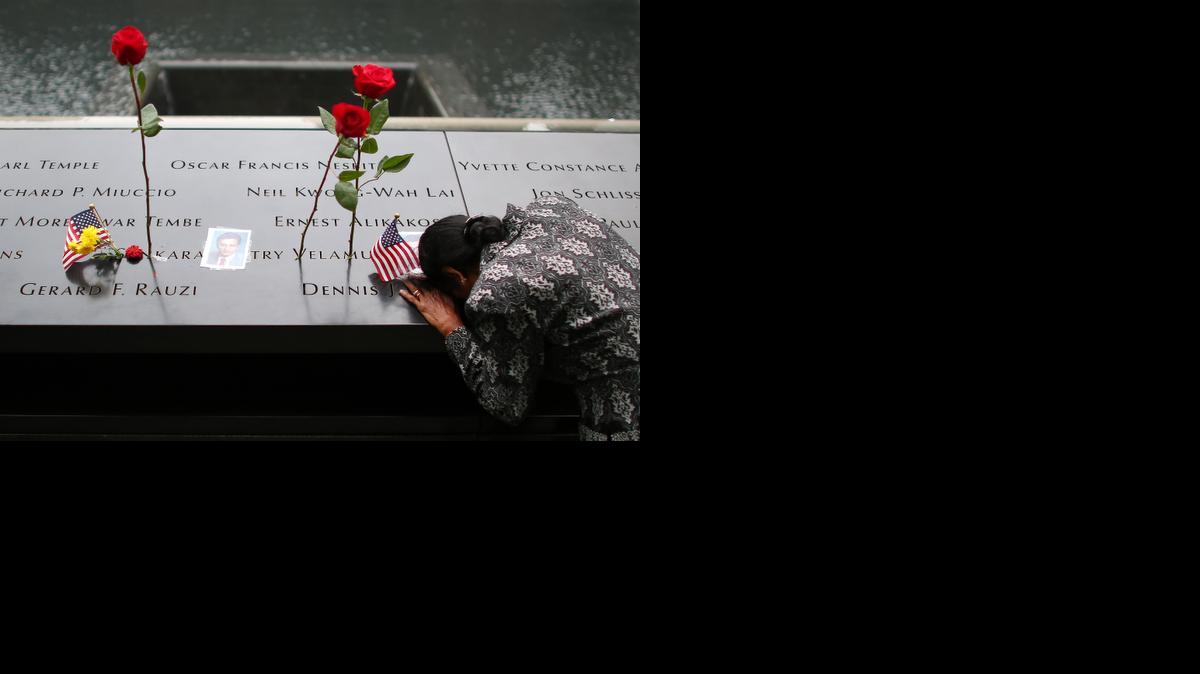 
A woman grieves at her husband's memorial at South Tower Memorial Pool during memorial observances on the 13th anniversary of the Sept. 11 terror attacks on the World Trade Center in New York, Thursday, Sept. 11, 2014. Family and friends of those who died read the names of the nearly 3,000 people killed in New York, at the Pentagon and near Shanksville, Pennsylvania.
