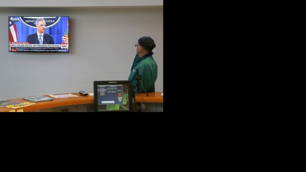 
Ank Ankenbrand, a 40-year resident of Ferguson. Mo., watches a television at the Ferguson Community Center Wednesday in Ferguson, Mo., as U.S. Attorney General Eric Holder delivers the department's report on the patterns and practices of the Ferguson police department. 
