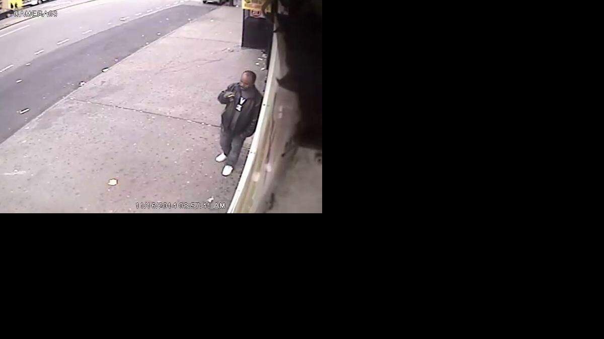 
In this surveillance video of Sunday, Nov. 16, 2014 provided by the New York Police Department, a man smokes a cigarette outside a convenience store in the Bronx borough of New York. The NYPD says the man is suspected of shoving a stranger off a subway platform Sunday in front of an oncoming subway train. Police said 61-year-old Wai Kuen Kwok was pushed off the platform to his death, an act that appeared to be unprovoked. 
