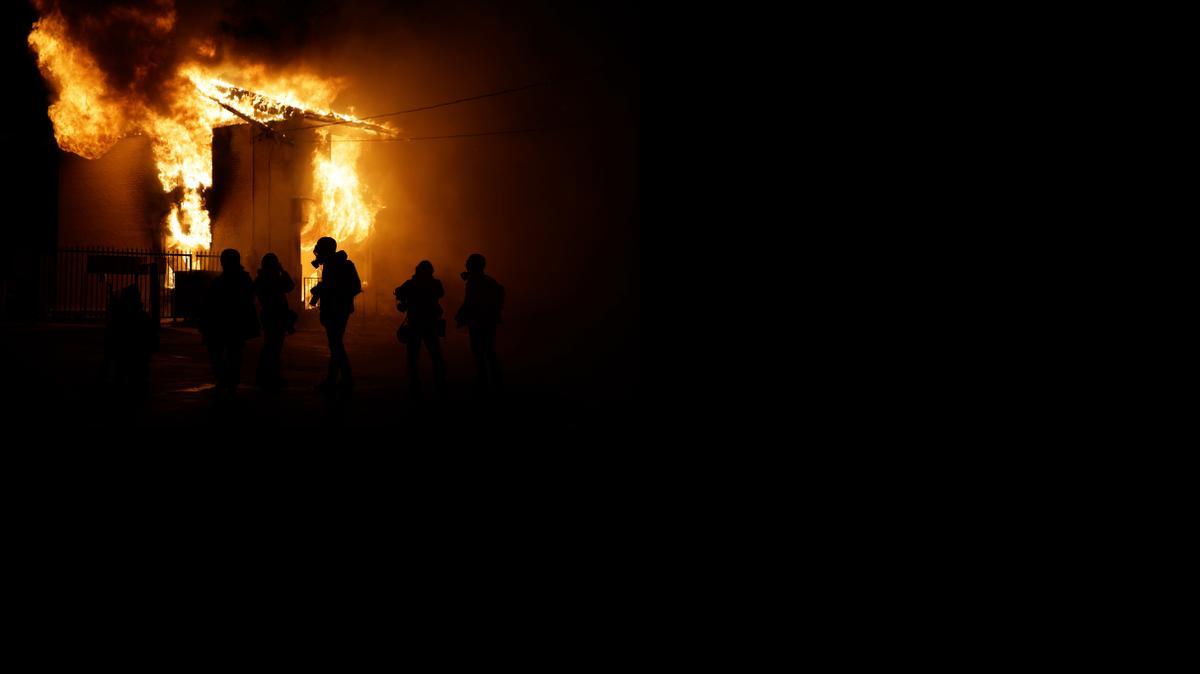 
Firefighters and members of the media arrive at the scene of a fire Monday night after the announcement of the grand jury decision in Ferguson, Mo., not to indict Ferguson police officer Darren Wilson in the death of Michael Brown. 
