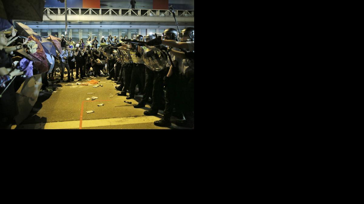 
Riot police officers try to stop protesters from moving forward on a pro-democracy protest encampment in the Mong Kok district of Hong Kong early Sunday.
