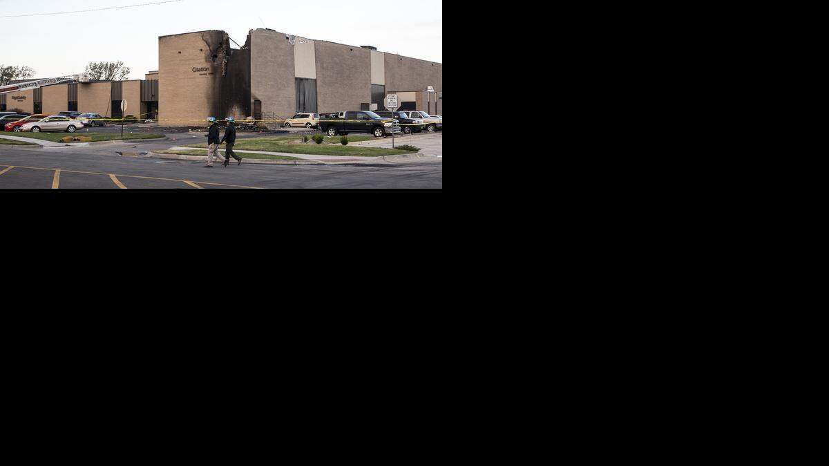 
Firefighters and other emergency workers stand ready to enter the FlightSafety building Friday after a twin-engine plane crashed into the building after takeoff Thursday. (Oct. 31, 2014)
