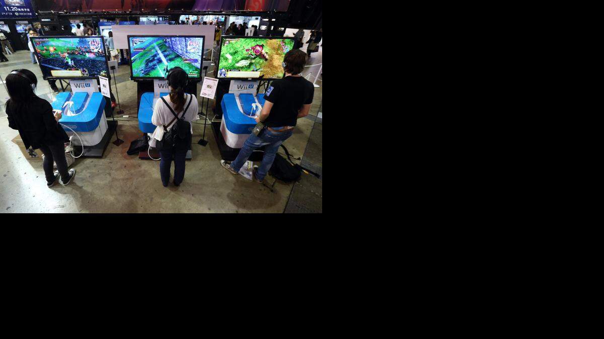 
Attendees play video games on Nintendo Co. Wii U game consoles at the Tokyo Game Show 2014 in Chiba, Japan, last week. Nintendo, now the world’s largest maker of video-game machines, was founded on this day in 1889 in Kyoto, Japan, as a playing card company.
