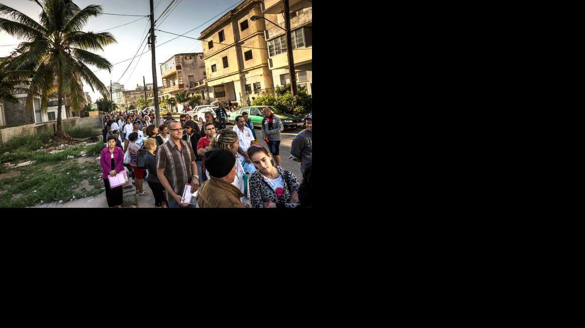 
Hundreds of Cubans wait in line to apply for tourist visas to visit the U.S., a common occurrence, at the American Interests Building in Havana, Dec. 18, 2014. 

