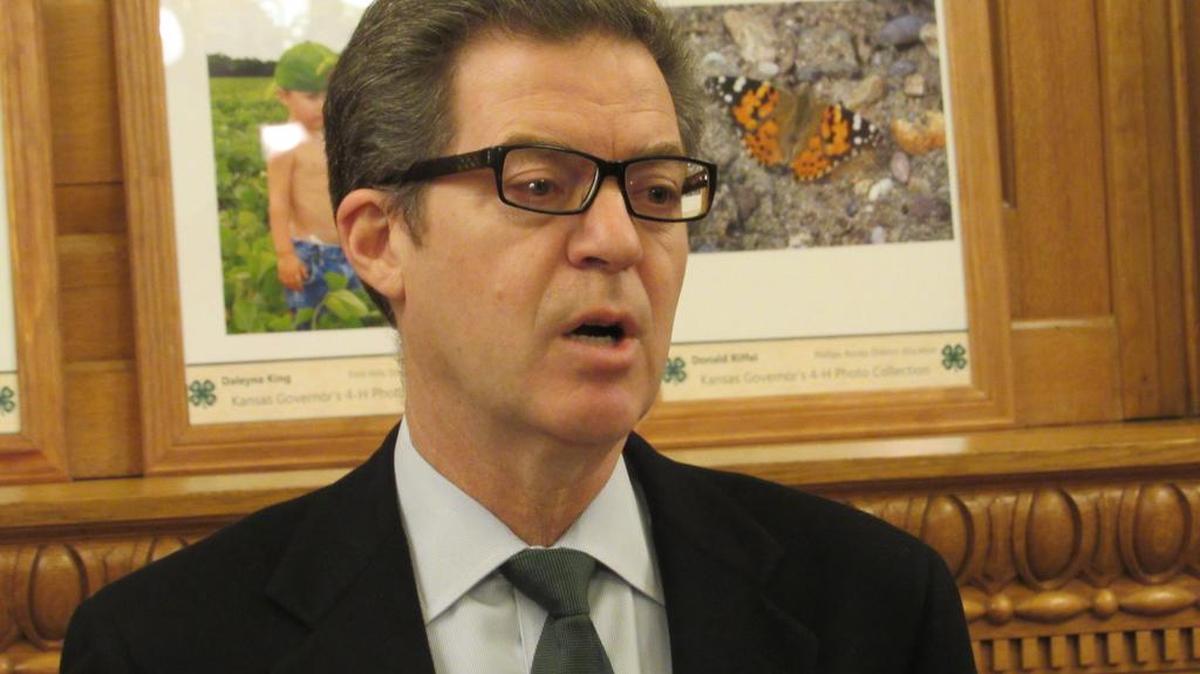 Gov. Sam Brownback takes questions from reporters Thursday.
