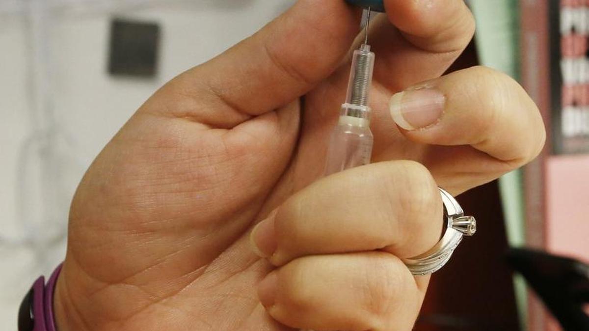 A community health nurse prepares to administer an immunization at the Sedgwick County Health Department. (July 20, 2015)