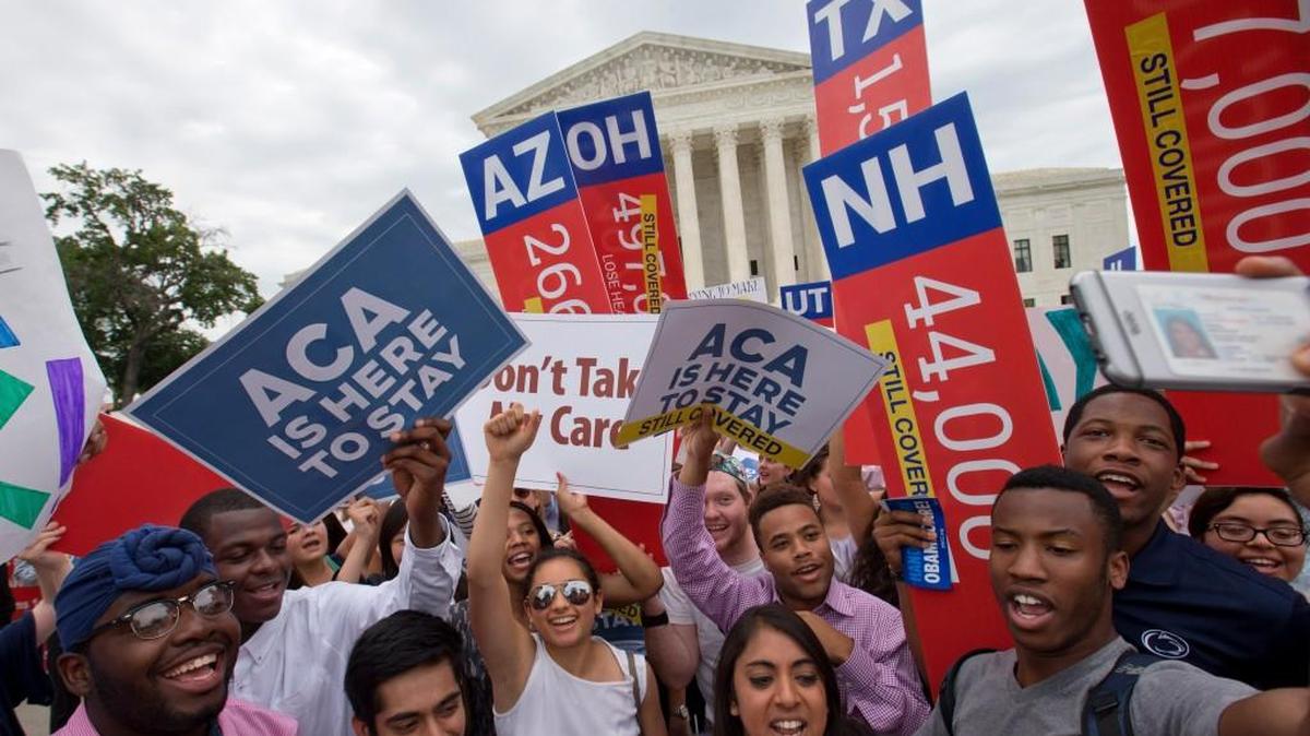 Demonstrators cheer outside the Supreme Court after the court decided the Affordable Care Act may provide nationwide tax subsidies.