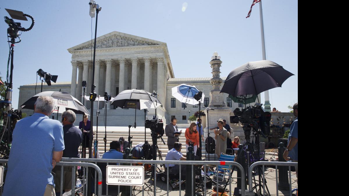 
News stations report as the final decisions from the Supreme Court begin to come in, Monday June 29, 2015, in Washington. Decisions are expected in three remaining three cases; on the use of a drug implicated in botched executions, partisan influence in congressional redistricting and EPA limits on emission of mercury and other toxic pollutants from power plants. (AP Photo/Jacquelyn Martin) 
