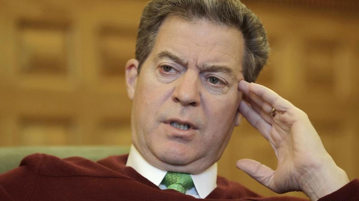 Kansas Gov. Sam Brownback talks to a reporter at his office on Dec. 14 in Topeka.