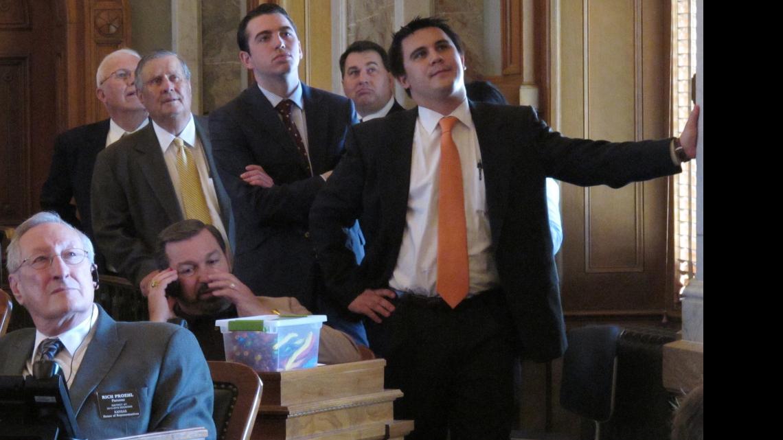 
Kansas state senators, Senate aides and Alexander Orel, right, an aide to Gov. Sam Brownback, stand in a side aisle of the House and watch one of its electronic tally boards as members vote on a tax plan, Friday, June 5, 2015, at the Statehouse in Topeka.

