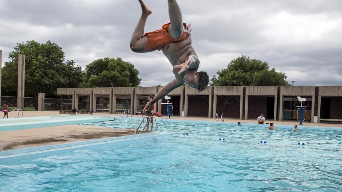 A swimmer does a flip off the diving board at McAdams swimming pool. (July 21, 2015)