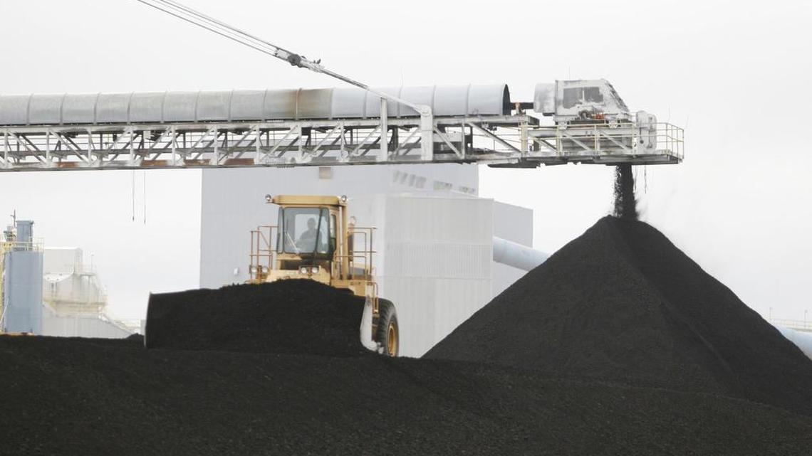 
High loaders move coal stockpiles at the Holcomb coal-fired power plant.
