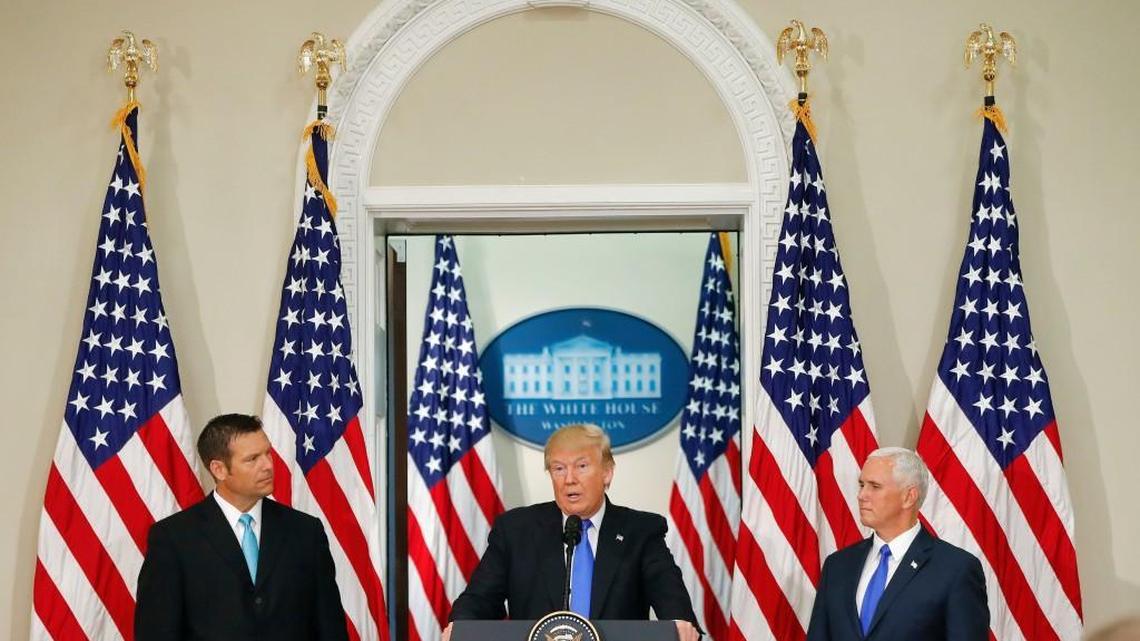 President Donald Trump, with Kansas Secretary of State Kris Kobach, left, and Vice President Mike Pence, right, speaks at a meeting of the Presidential Advisory Commission on Election Integrity, Wednesday, July 19, 2017, in the Eisenhower Executive Office Building on the White House complex in Washington.