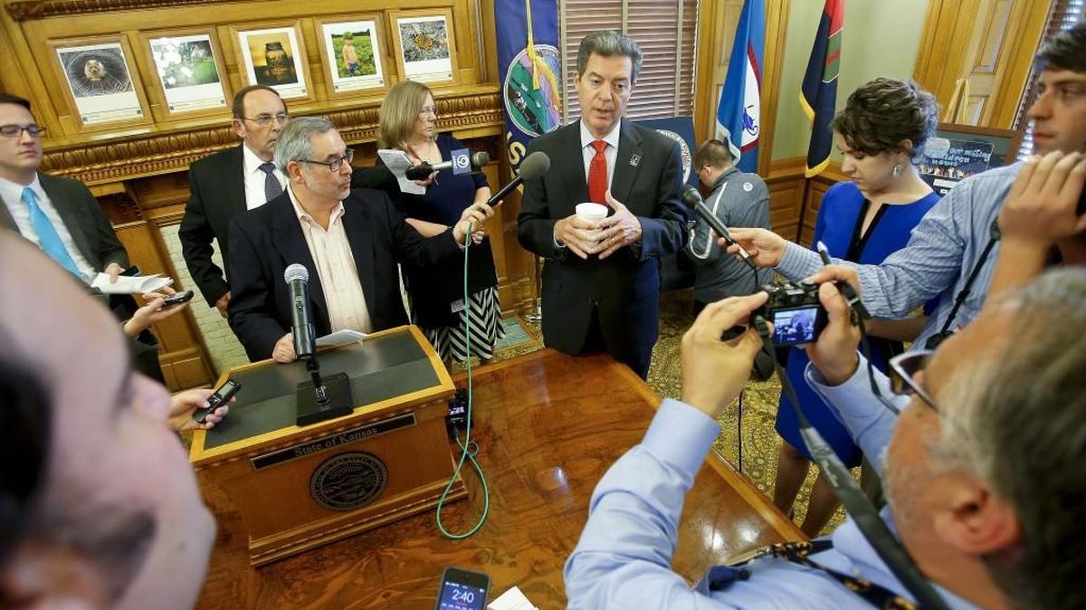 Kansas Gov. Sam Brownback answers questions from the media during a news conference in August.