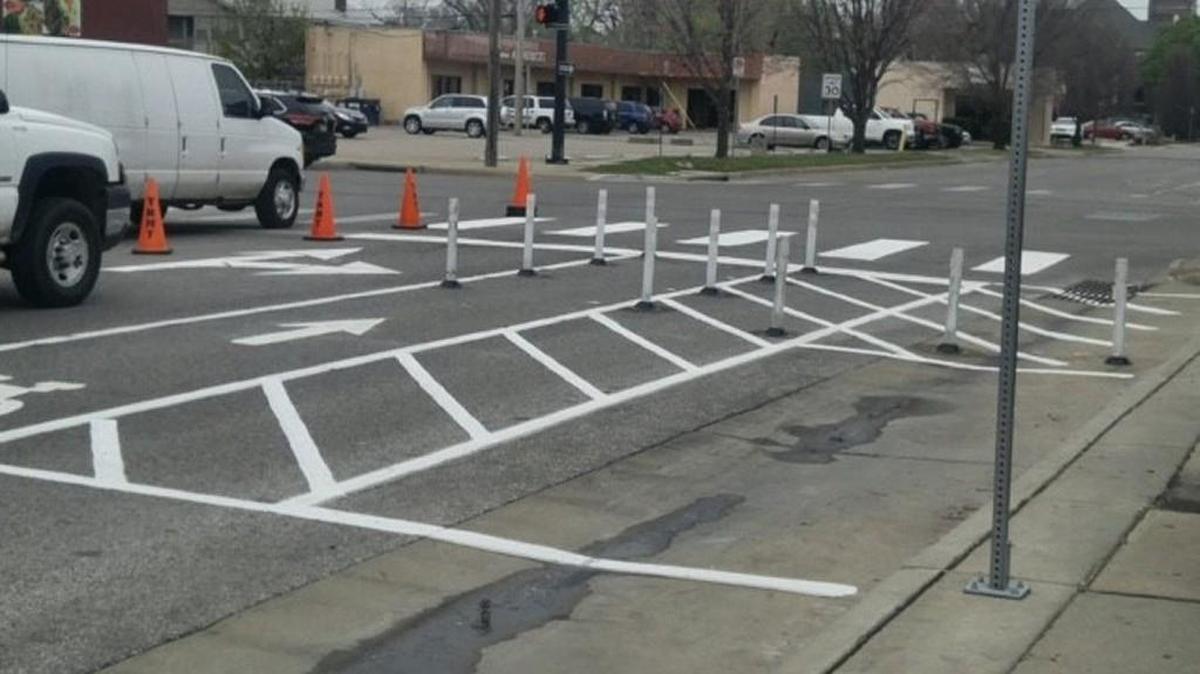Crews repositioned posts across a bike lane at First and Washington to discourage motorists from cutting into the lane to turn right.