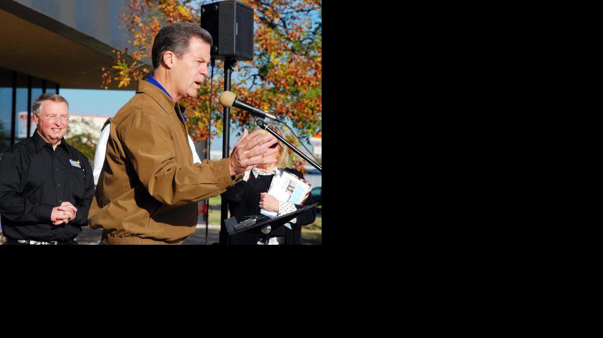 
Gov. Sam Brownback speaks at a rally outside Summit Church with pastor Terry Fox, left, on Saturday morning. (Oct. 18, 2014)
