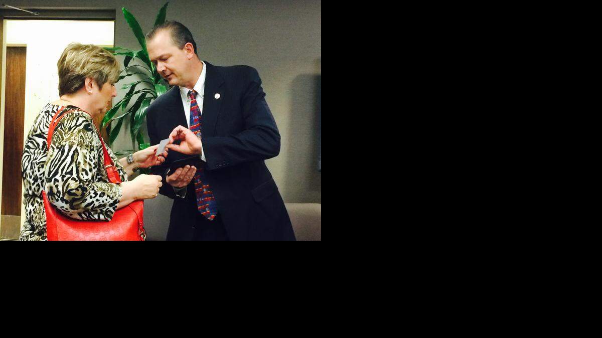 
Outgoing Sedgwick County Commissioner Jim Skelton hands a card to Paula Donagan, who served on his District 5 advisory board, so she could stay in touch with him. (Jan. 7, 2015)
