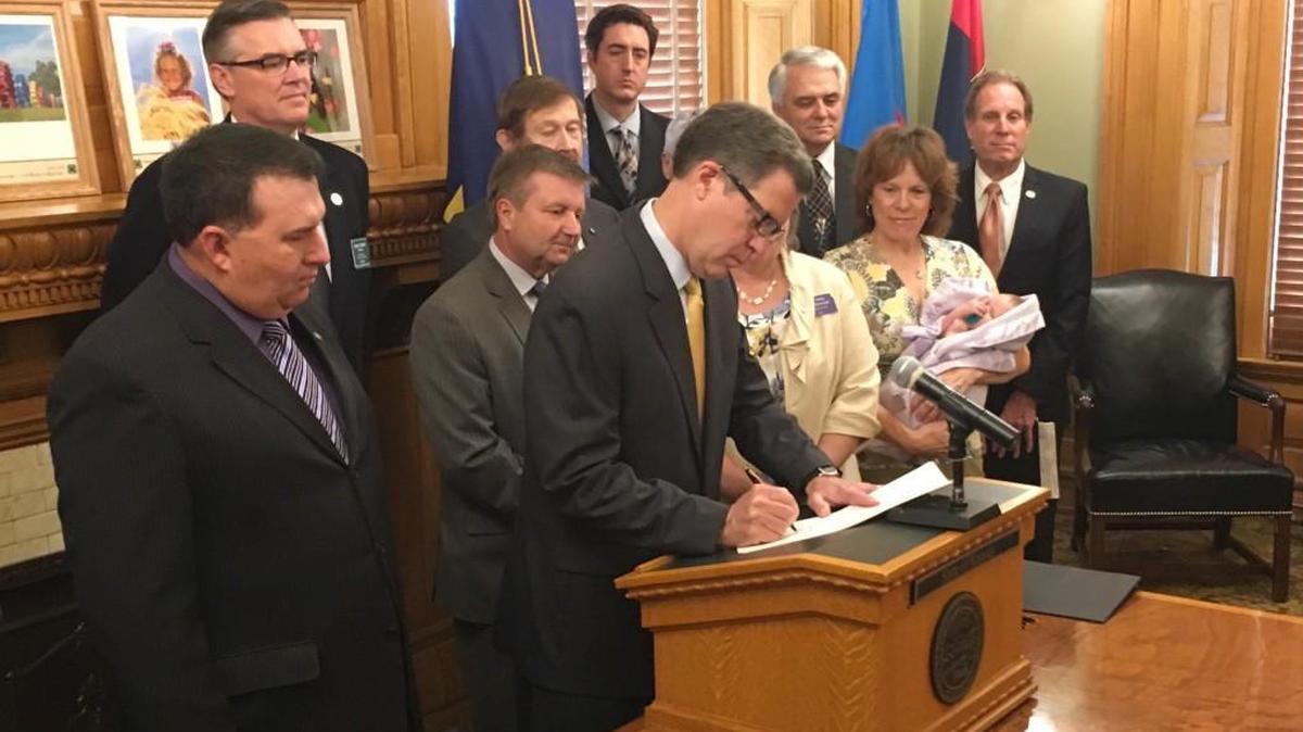 Gov. Sam Brownback signs a bill into law Wednesday that requires additional information to be provided to women considering an abortion and sets font and type size requirements for the information.