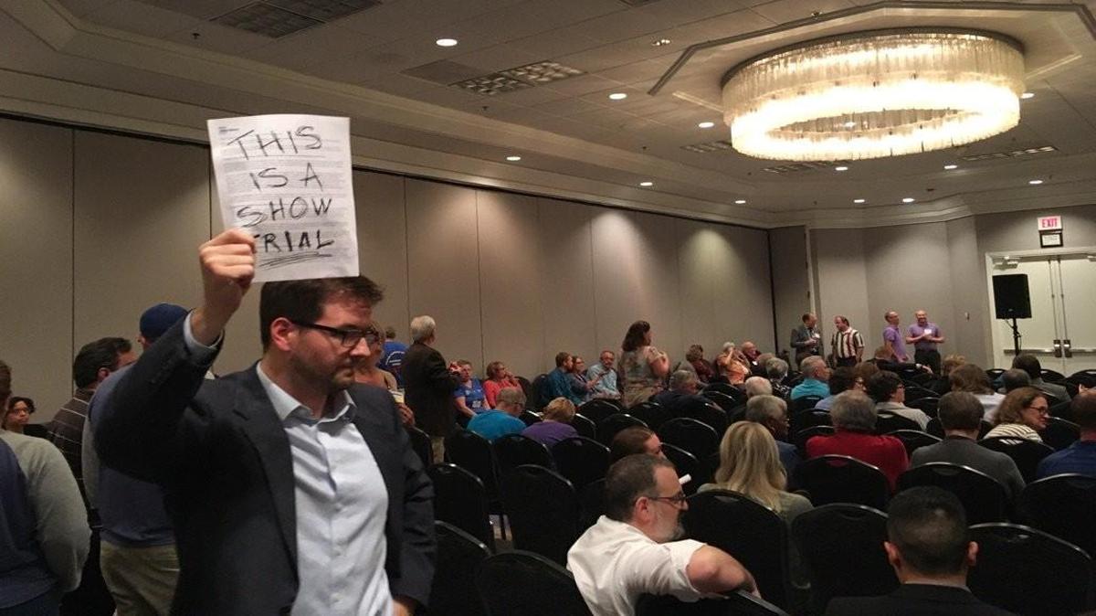 Chris Pumpelly holds up a sign during a meeting of the Kansas Democratic Party’s state committee on Saturday. Democrats met to decide whether to recall Party Secretary Casey Yingling.