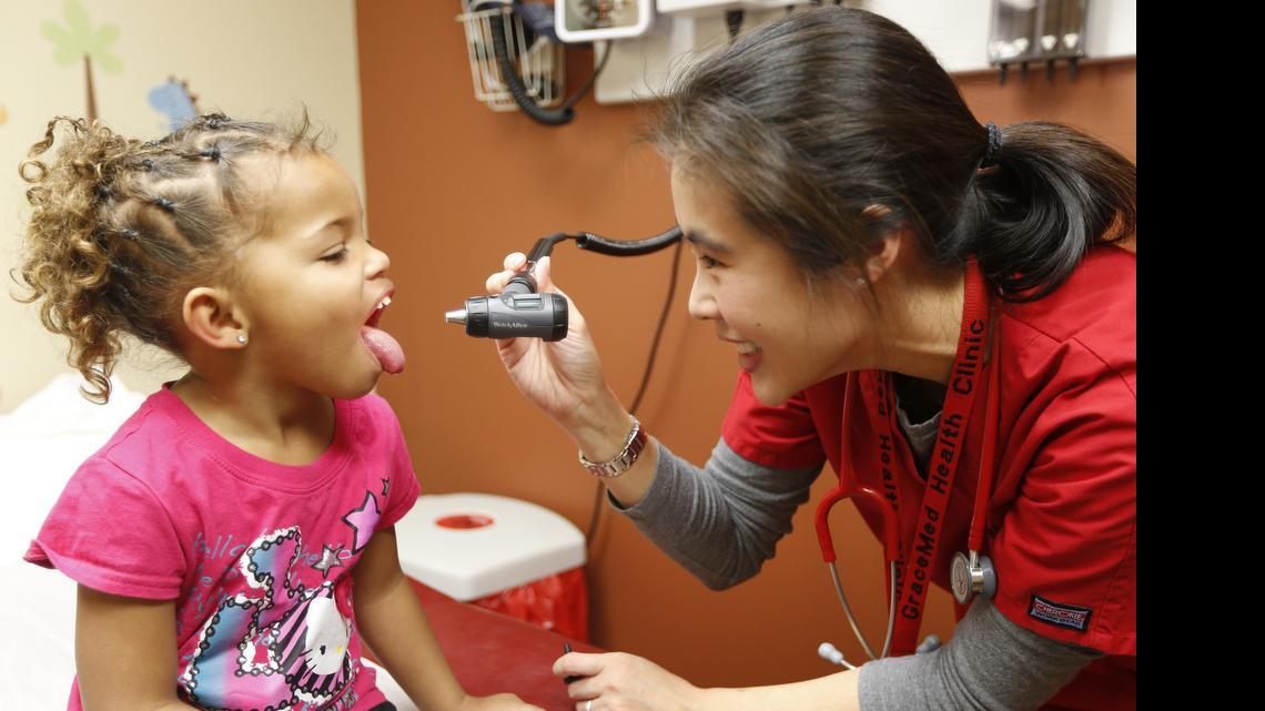 
A girl is treated at GraceMed Clinic. The rate of Americans without health insurance coverage has fallen in all 50 states, according to Census data.

