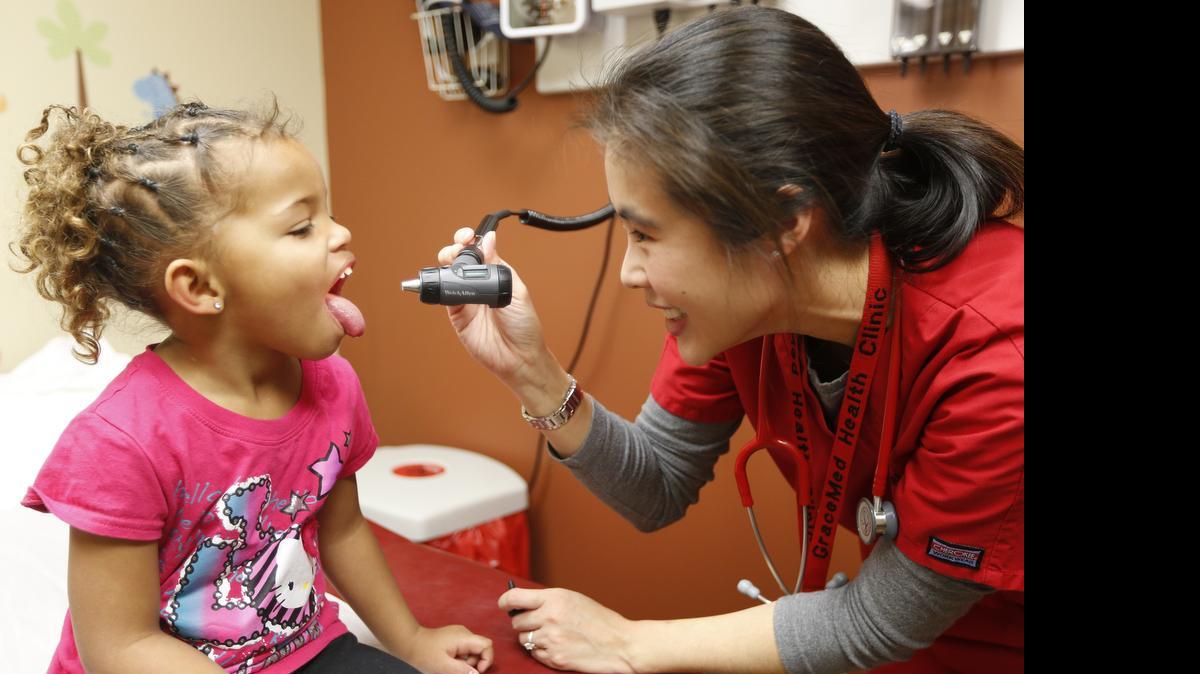 
A girl is treated at GraceMed Clinic. The rate of Americans without health insurance coverage has fallen in all 50 states, according to Census data.
