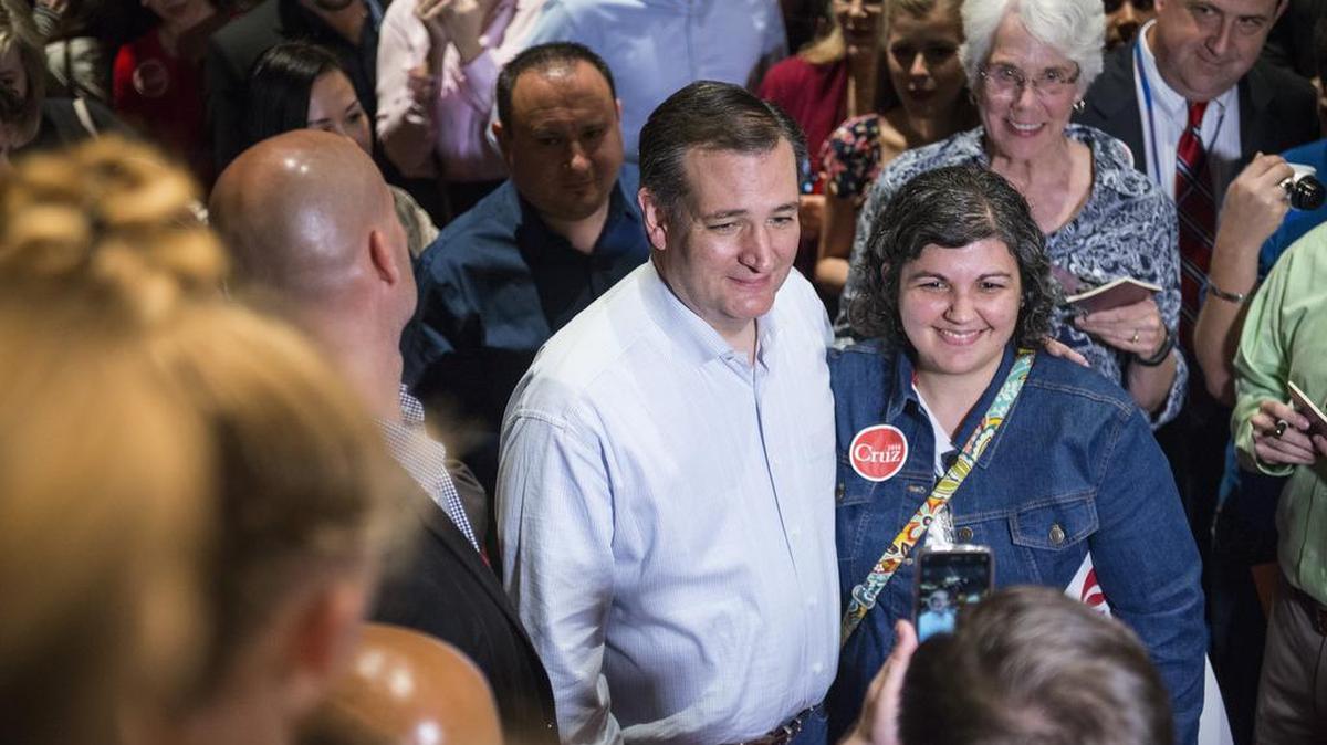 Sen. Ted Cruz, a Republican from Texas and 2016 presidential candidate, center, poses for a photograph with an attendee during a campaign event in Houston on Monday. He will visit Johnson County on Wednesday.