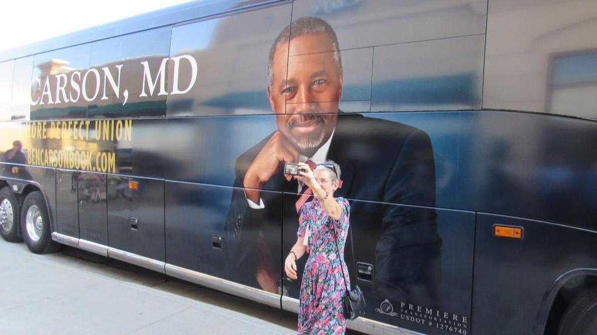 Bibi Zweig, 61, takes a selfie in front of a tour bus for Republican presidential candidate Ben Carson in Topeka. Carson signed books and spoke to supporters at Barnes & Noble bookstore.