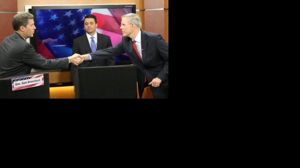 
Kansas Gov. Sam Brownback, left, and Democratic challenger Paul Davis shake hands after a televised debate hosted by KWCH-TV and moderated by Michael Schwanke. (Oct. 20, 2014)
