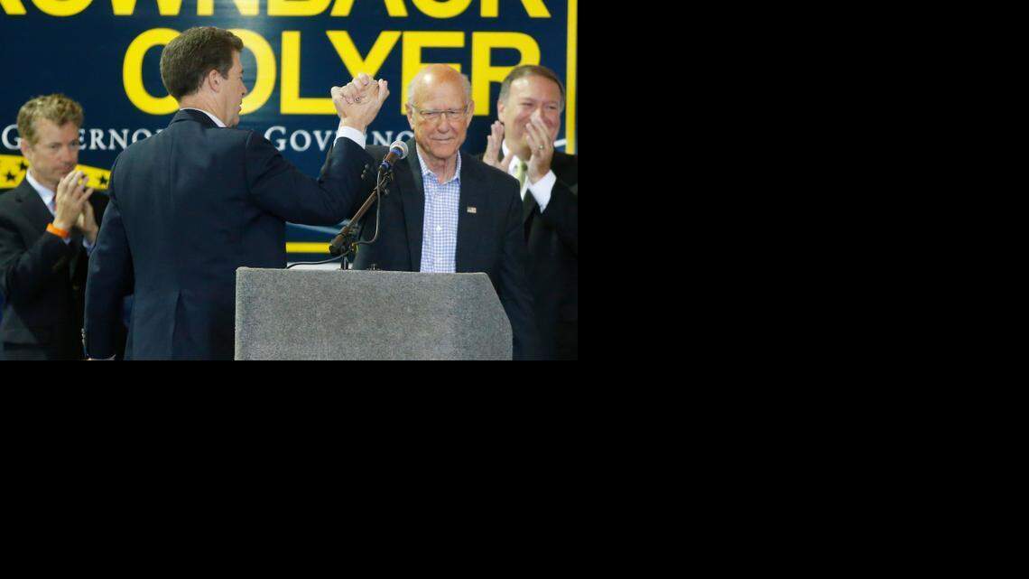 
Gov. Sam Brownback, left, and U.S. Sen. Pat Roberts high-five each other during a rally in Wichita in October.  (Oct. 28, 2014)
