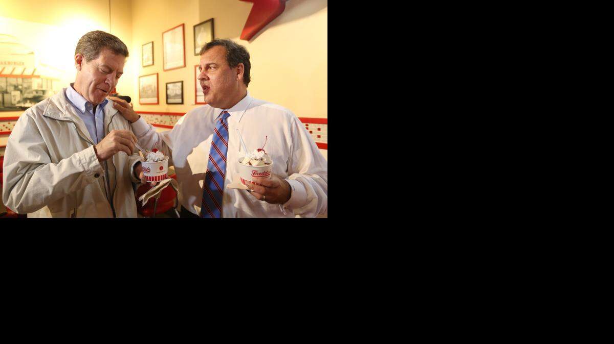 
New Jersey Gov. Chris Christie, right, told Kansas Gov. Sam Brownback that he had not steered him wrong about the good food at Freddy’s Frozen Custard. The pair ate turtle sundaes while visiting with supporters on Monday. (Oct. 13, 2014)
