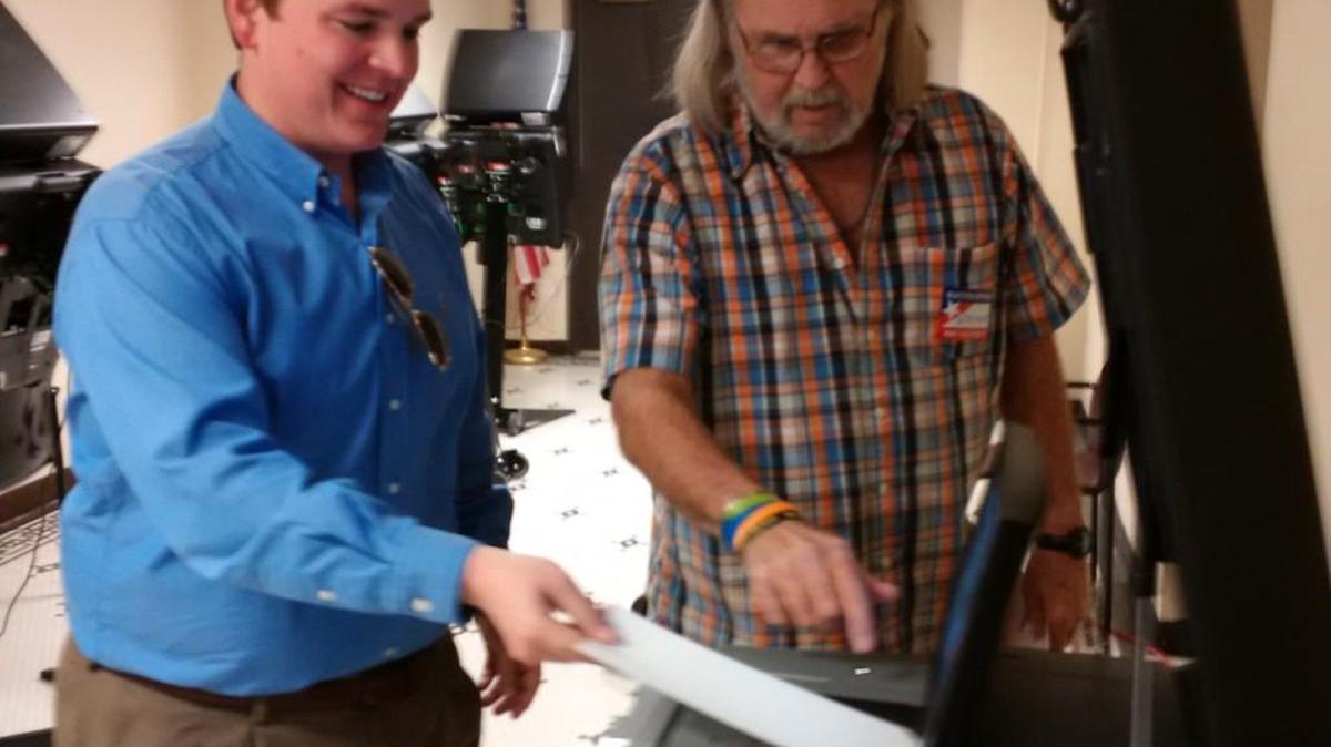 Sedgwick County Commissioner Michael O’Donnell, left, casts his ballot with help from poll worker Wayne Selvidge. O’Donnell was the 35th and penultimate voter on the first day to vote an advance ballot in the city/school board election.