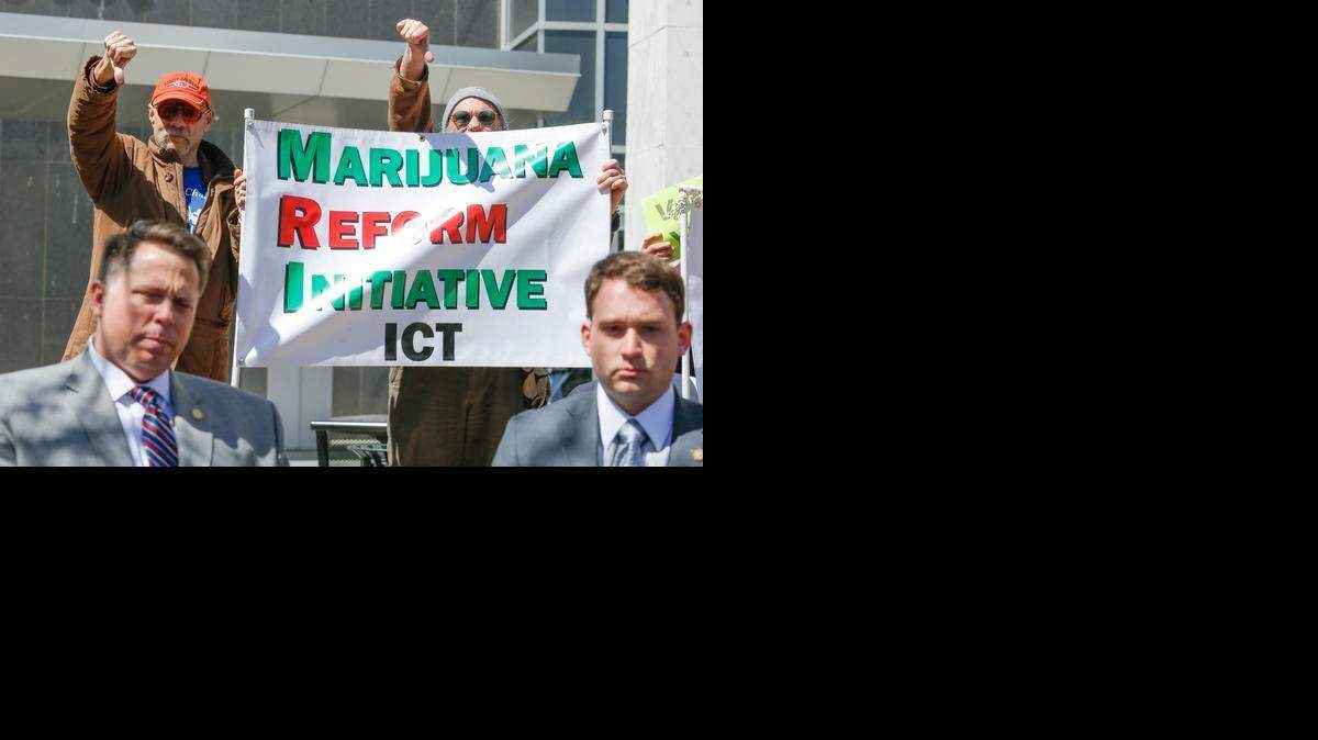 
Supporters of the Marijuana Reform Initiative give a thumbs-down to a group of lawmakers and state officials who spoke outside the Sedgwick County Courthouse on April 3, 2015, prior to Wichita's marijuana initiative appearing on the April 7 ballot. The initiative was approved by voters.
