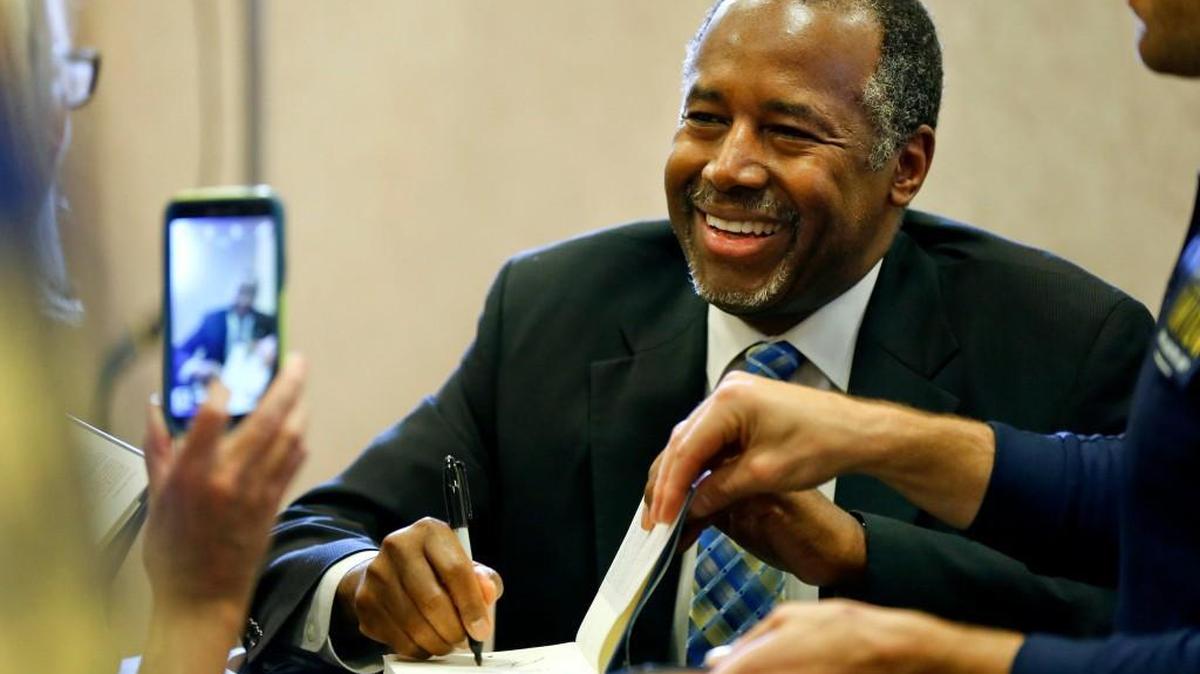Republican presidential candidate Ben Carson signs a copy of his book on Friday, Oct. 23, 2015, at a Topeka bookstore.