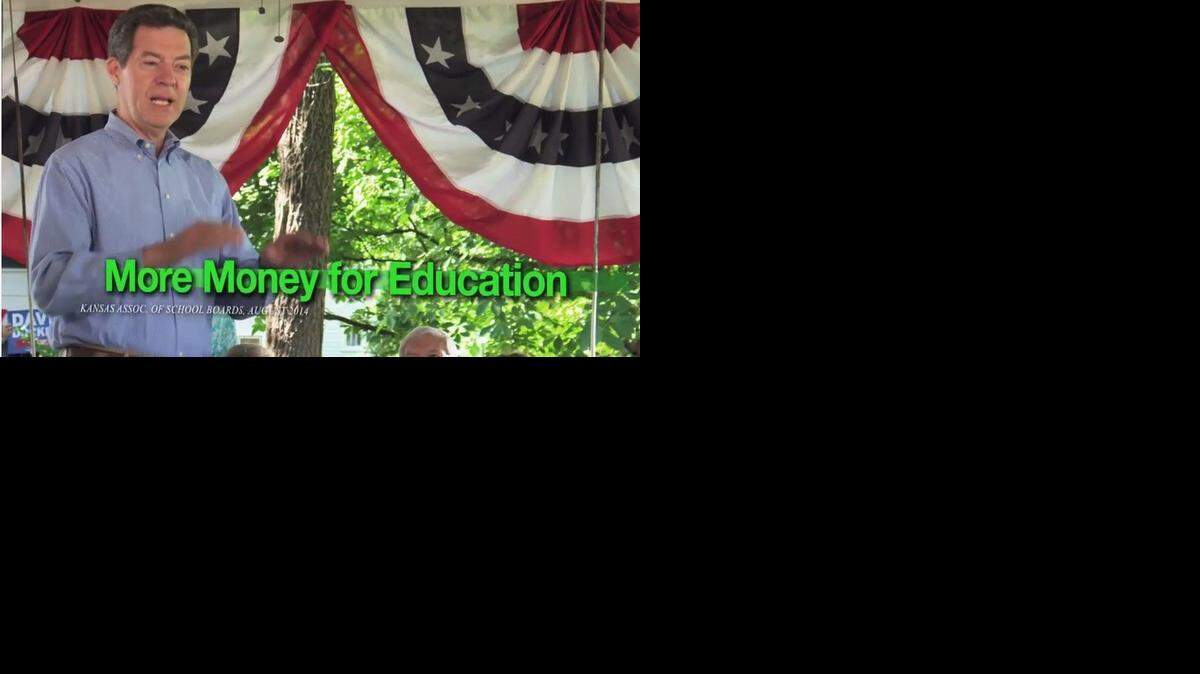 
A screenshot of the Sam Brownback re-election ad where a Davis-Docking sign is visible in the lower left corner of the background.
