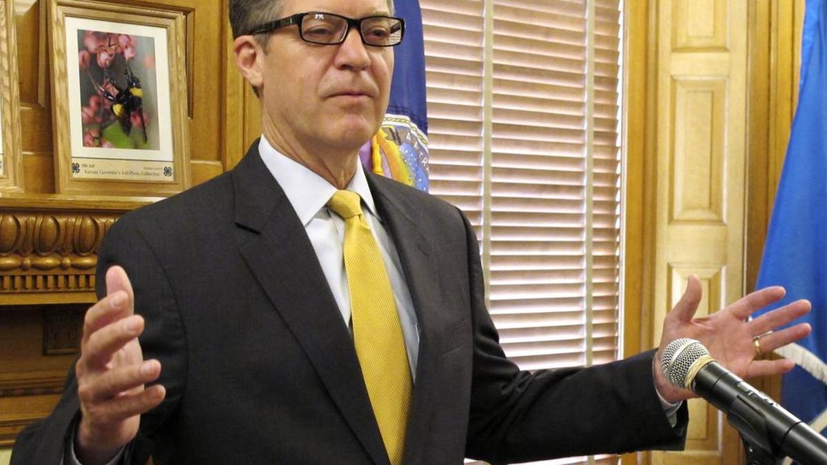 Kansas Gov. Sam Brownback comments during a news conference about the Legislature’s override of his veto of a bill increasing income taxes to fix the state budget on June 7.