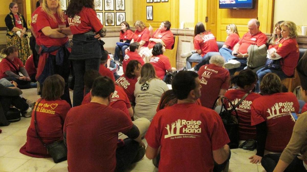 Members of the Kansas National Education Association sit outside the Kansas House chamber in Topeka following a debate on school funding legislation in 2014.