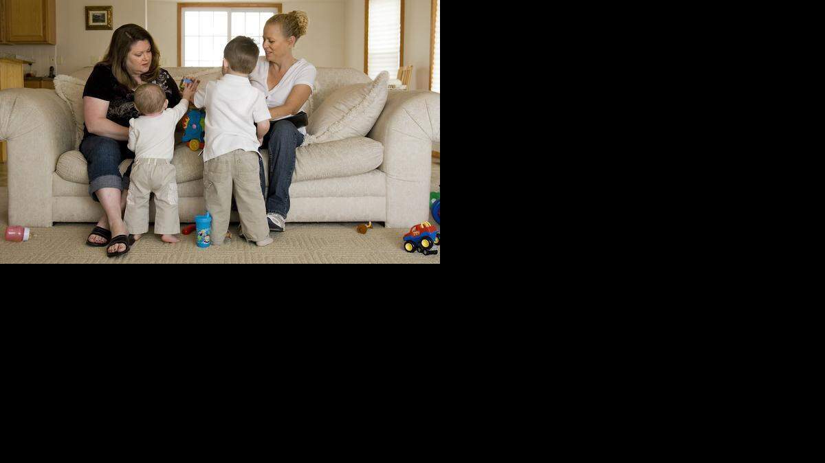
A social worker, right, and a foster parent interact with two foster sons in a Wichita home. Under a Kansas Senate proposal, in order to become a CARE family, a husband and wife would have to be married for at least seven years and at least one of the pair could not work outside the home. 
