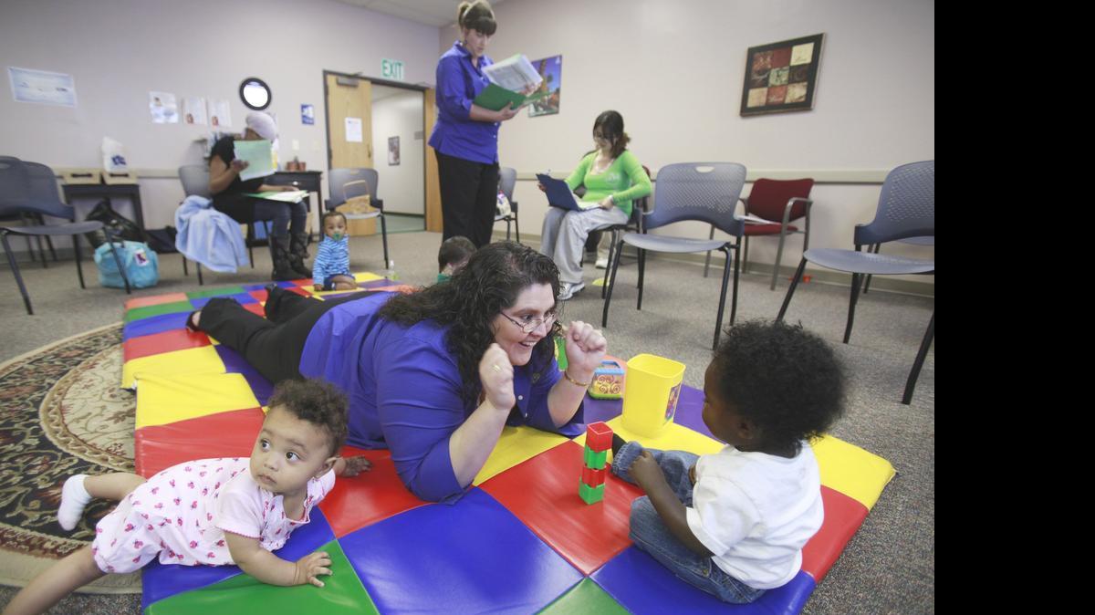 
Christina Rodriquez, an RNBSM, plays with babies during a monthly meeting of a parenting group in the Sedgwick County Healthy Babies program. (2011)
