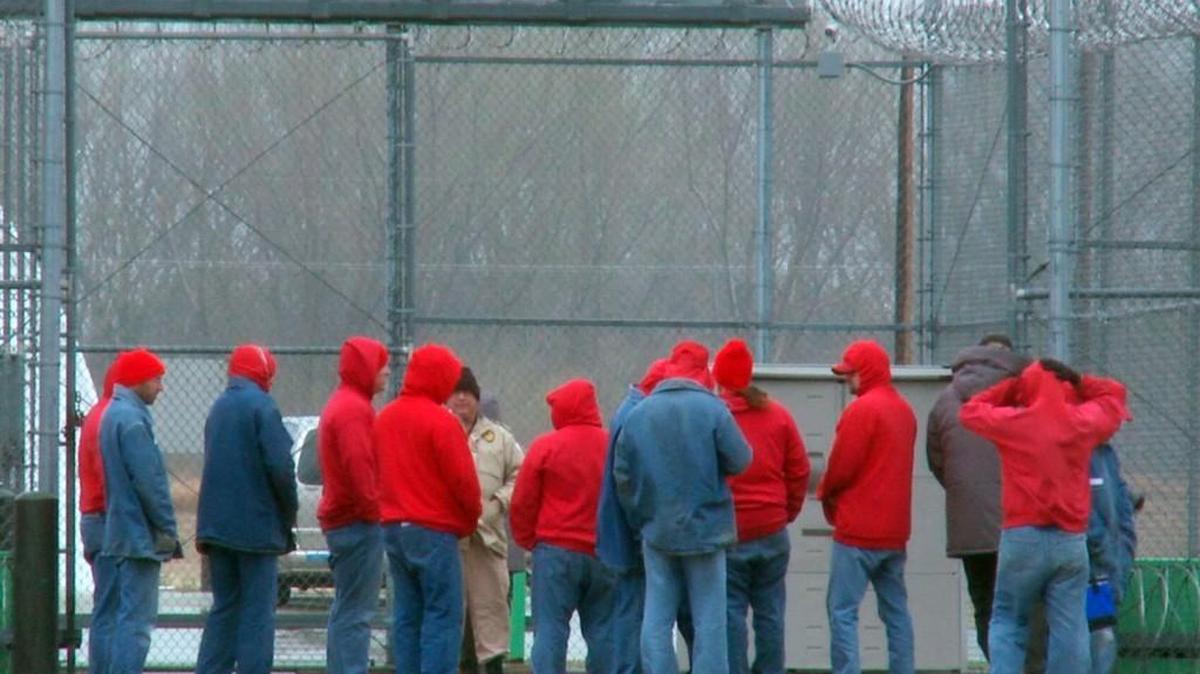 Inmates stand in an enclosed area inside the Larned Correctional Mental Health Facility.