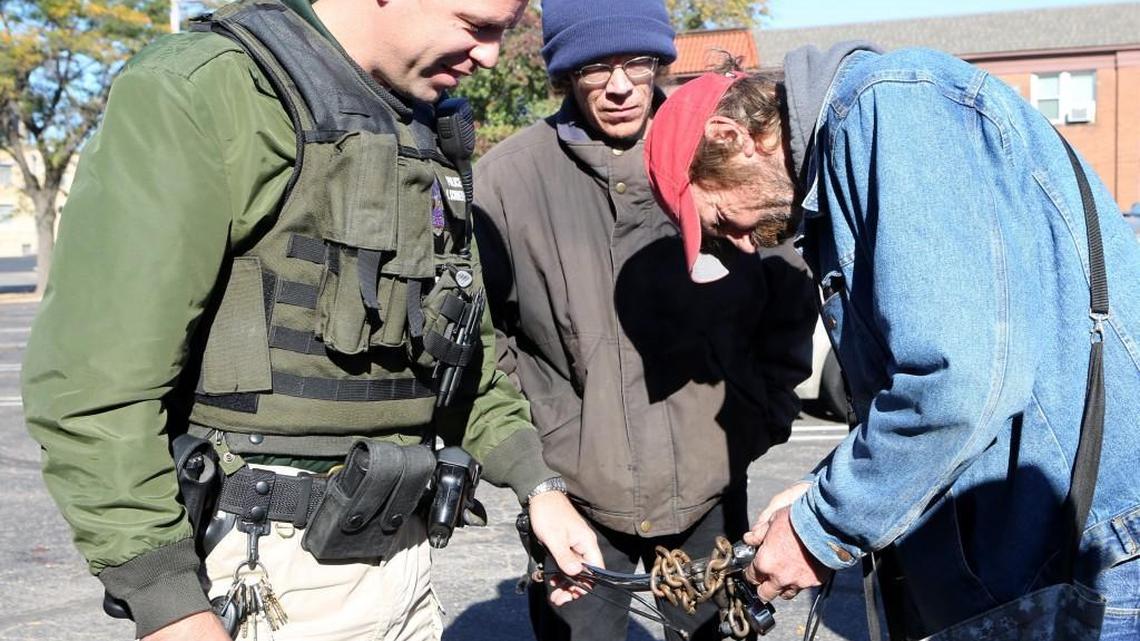 Wichita police Officer Nate Schwiethale gives Steve Weathers, right, a free LED bicycle light at United Methodist Open Door in October. Schwiethale is a member of the Police Homeless Outreach Team.