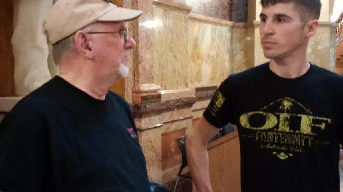 Jeremy Kettler, right, visits with supporter David Gift after Wednesday’s rally at the Capitol in Topeka. Kettler and his supporters are fighting his federal firearms conviction.