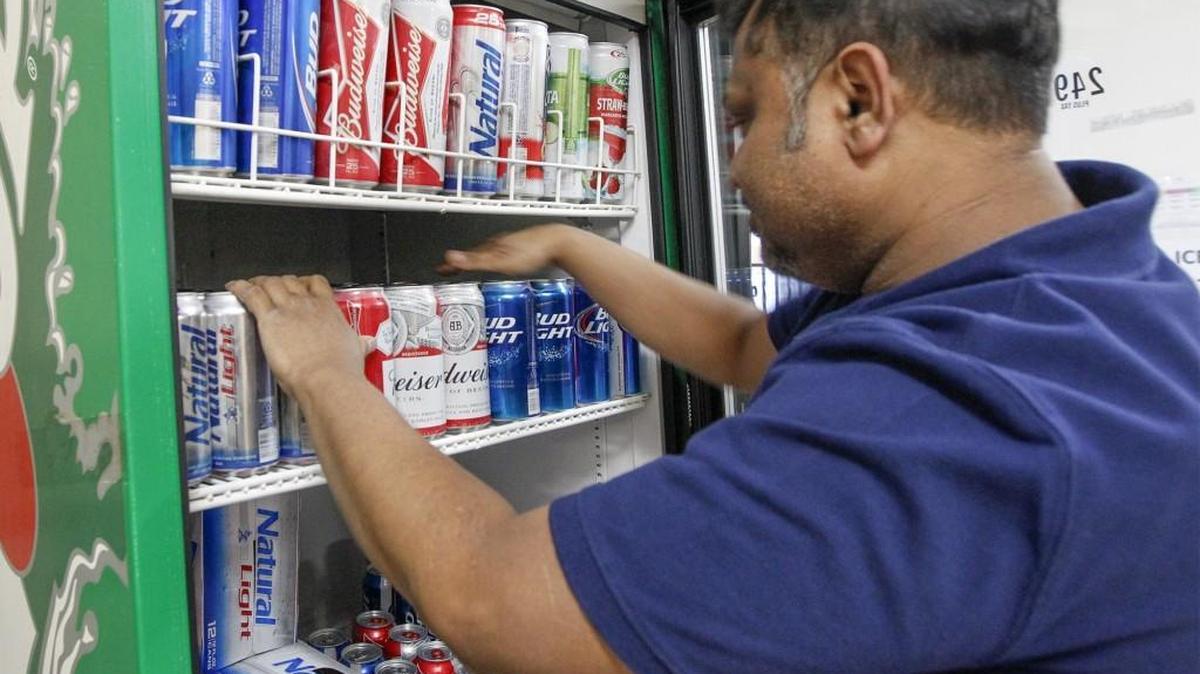 A Moe’s Mart employee stocks a cooler with 3.2 percent beer.