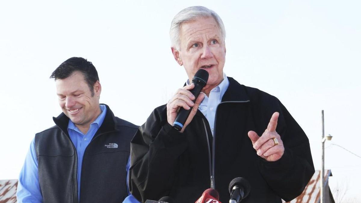During a campaign stop, Kansas Secretary of State Kris Kobach, left, listens as Wink Hartman, right, speaks on March 21, 2018, in Topeka. Kobach named Hartman as his running mate in his campaign for Kansas governor.