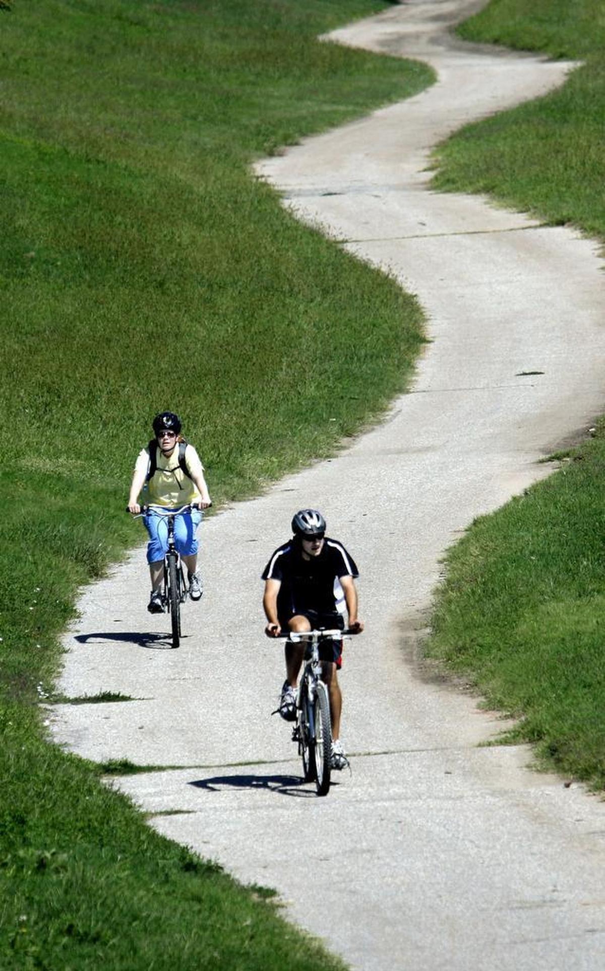 Cyclists bike on one of the city's bike paths near the Arkansas River.