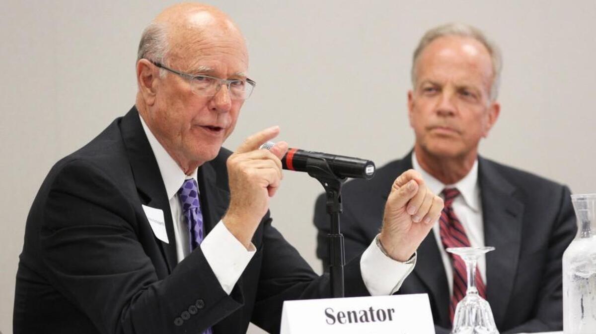 Sen. Pat Roberts, left, R-Kan, makes opening remarks at the 2014 Congressional Summit, while Sen. Jerry Moran, R-Kan, listens. The two are at odds over the latest Senate health care bill.
